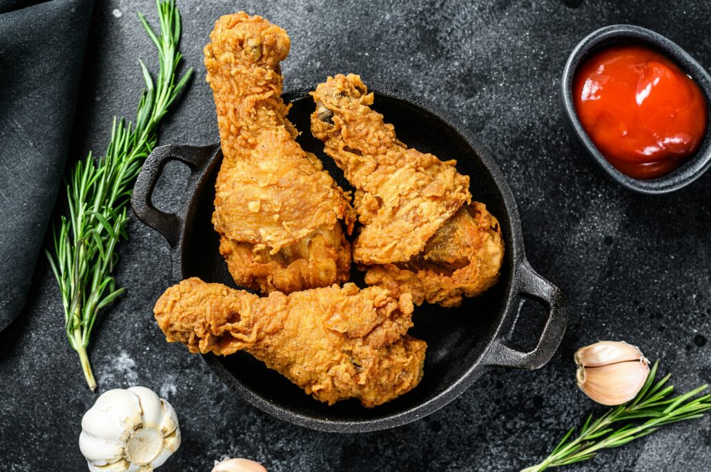 Spicy Deep Fried Breaded Chicken drumsticks. Black background. Top view