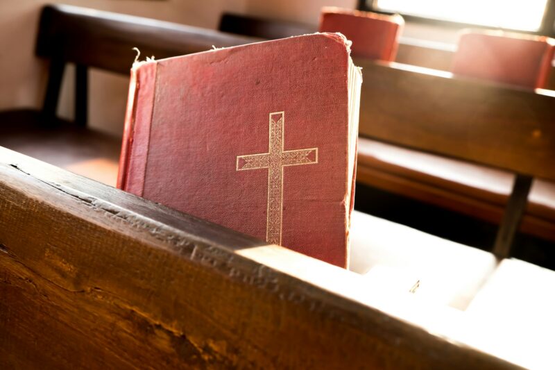 The old red worship songbooks at bench in the church.