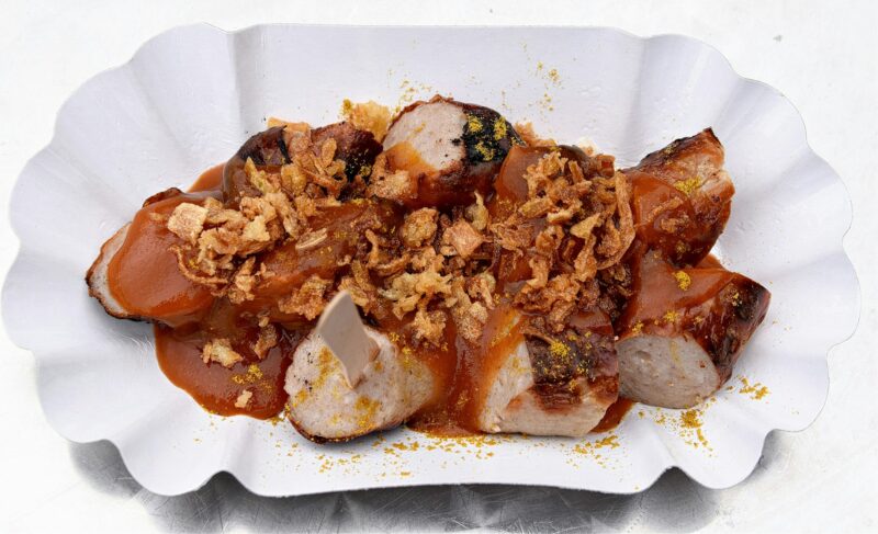 traditional German Currywurst with sauce and roasted onions