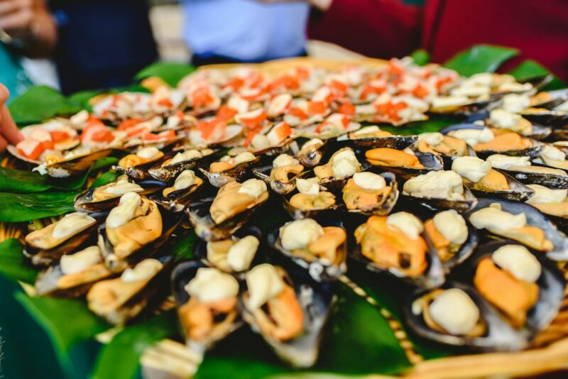 Tray of cooked mussels with spices served at a gastronomic party.