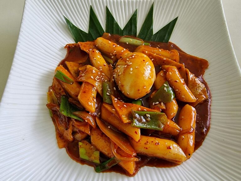 Tteokbokki or korean rice cake stir fried in sweet chilli paste,fish cake and served with an egg
