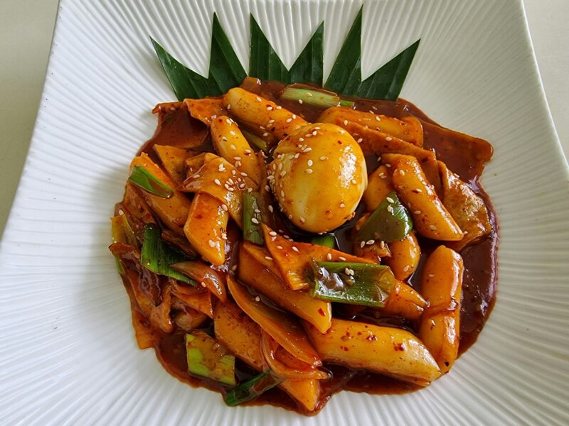 Tteokbokki or korean rice cake stir fried in sweet chilli paste,fish cake and served with an egg