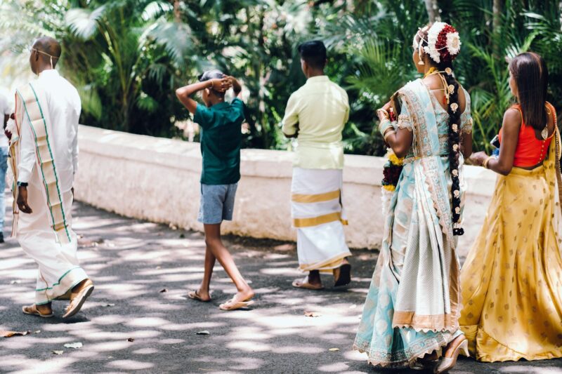 unrecognizable Locals in traditional outfits walk through the Park of the island of Mauritius