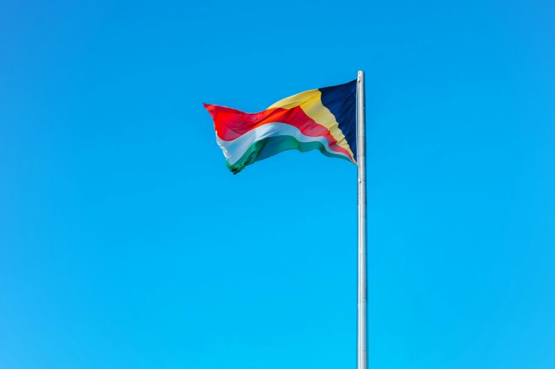Waving colourful flag of Seychelles on a blue sky background