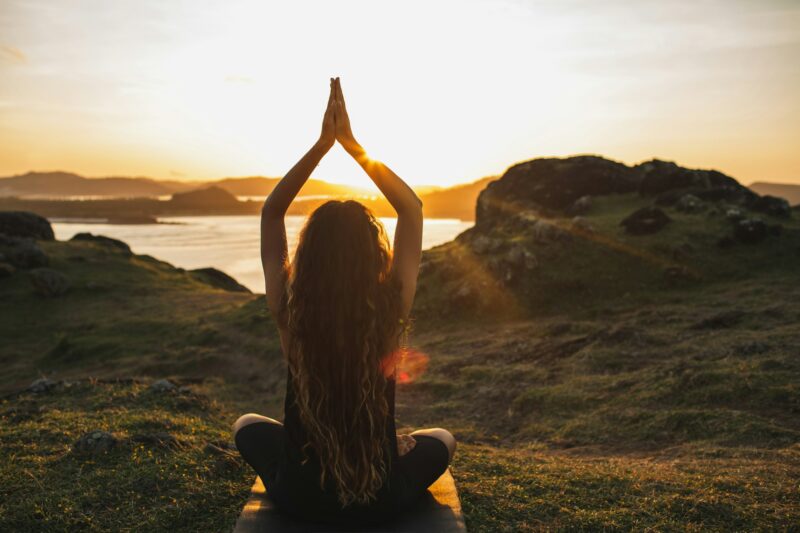 Young woman practicing yoga outdoors. Spiritual harmony, introspection and well-being concept